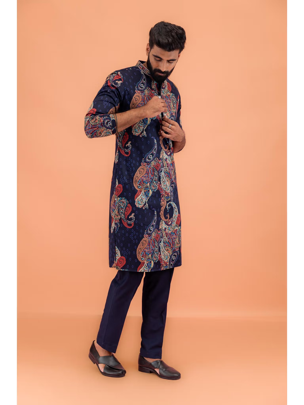 Model wearing men's black printed kurta Canada with colorful paisley print navy pants and black loafers