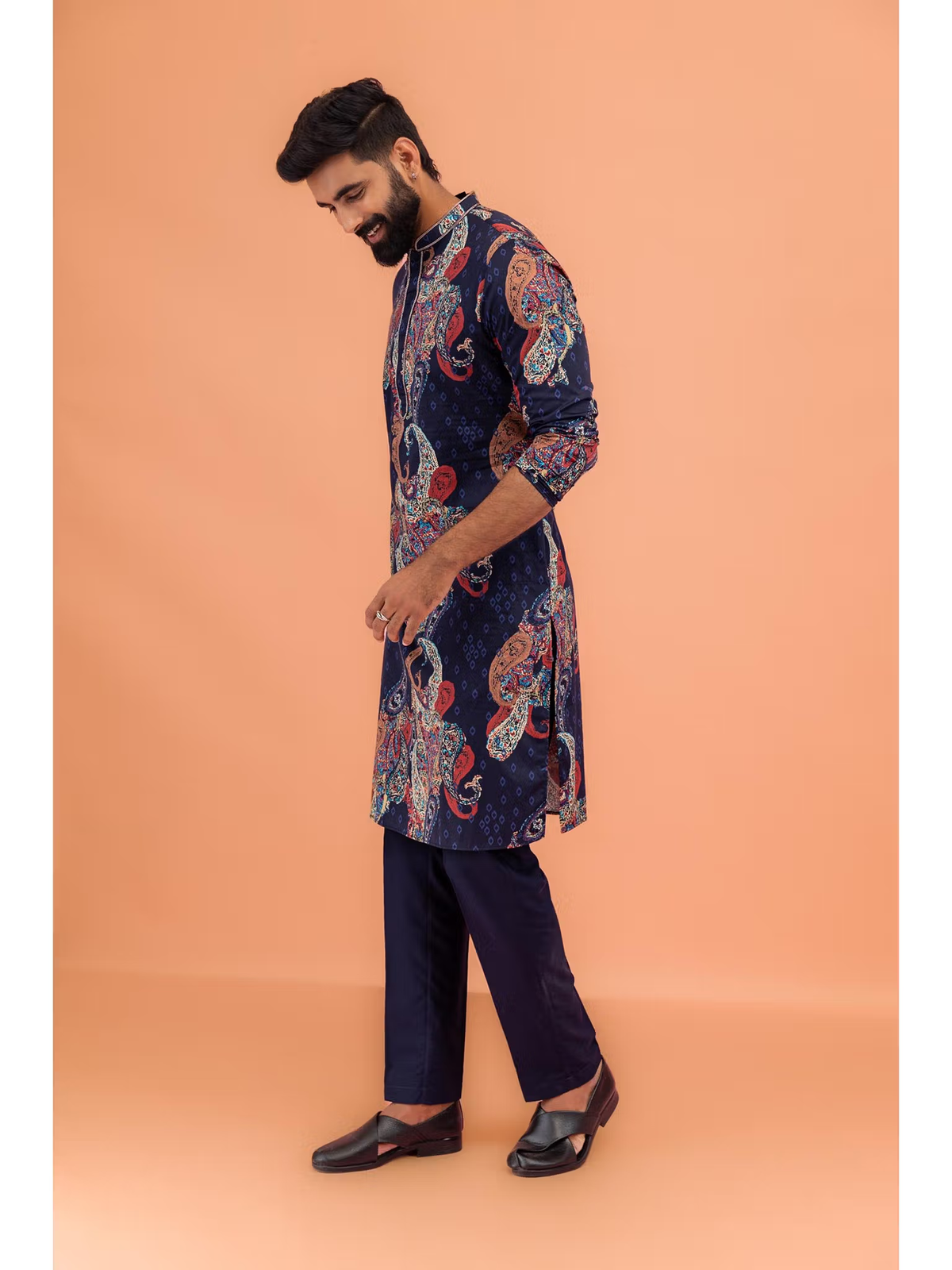 Model wearing men's black printed kurta Canada navy paisley pattern side profile with matching trousers and black shoes