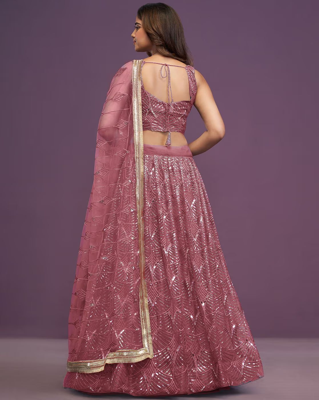 Back view of mauve sequined embroidered lehenga choli set Canada with tie back blouse and gold border dupatta