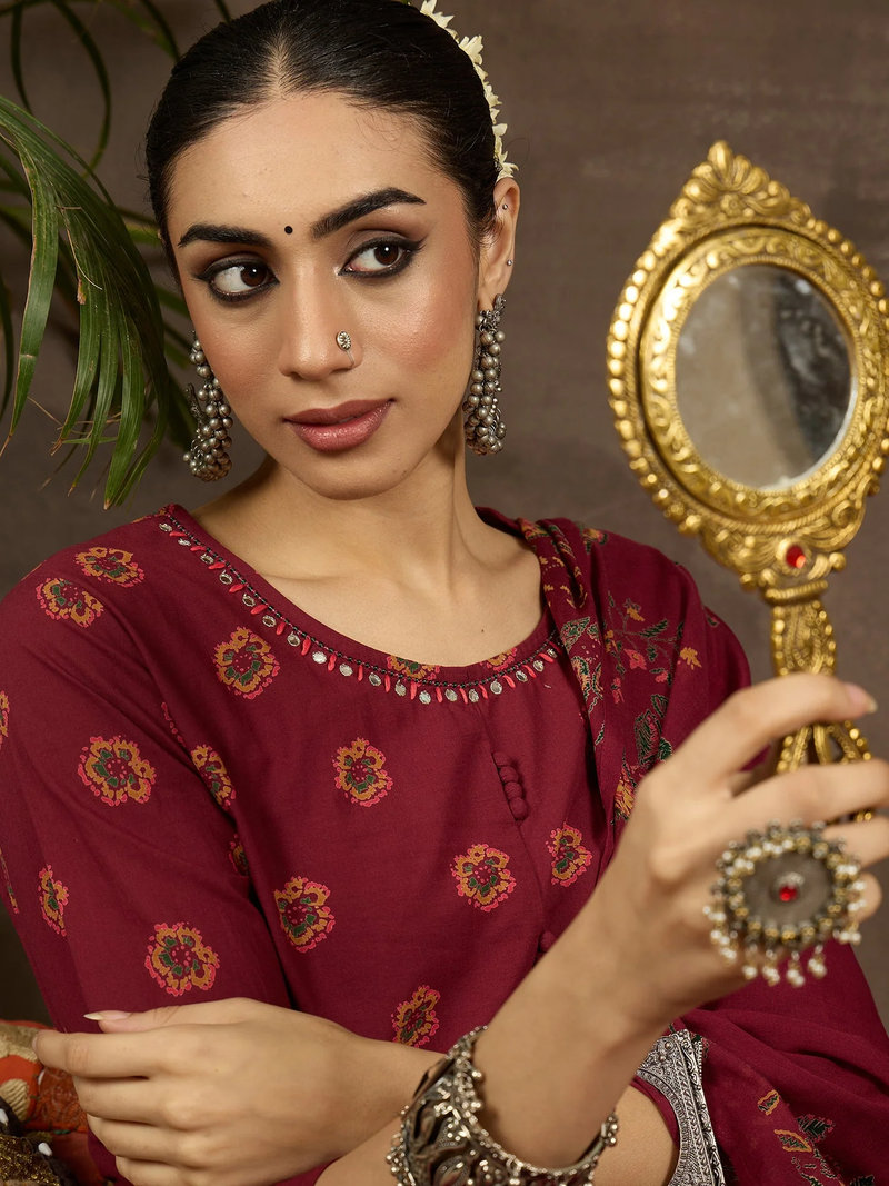 Woman in traditional attire holding a decorative mirror