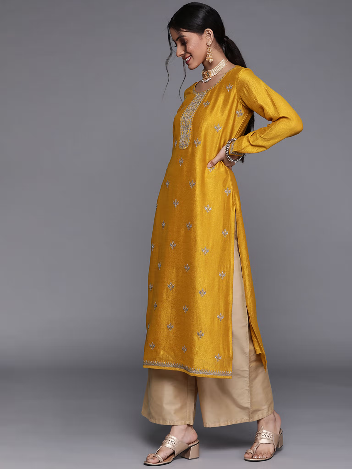 Aromie mustard yellow single piece kurta paired with beige eco-friendly palazzo jumpsuit and traditional jewelry