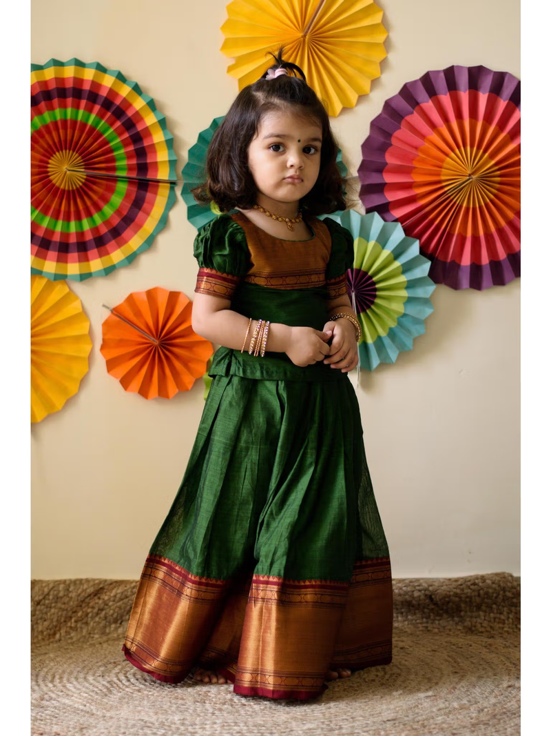 aromie girls shirt dress Canada green silk traditional dress with gold border worn by toddler against colorful paper fans