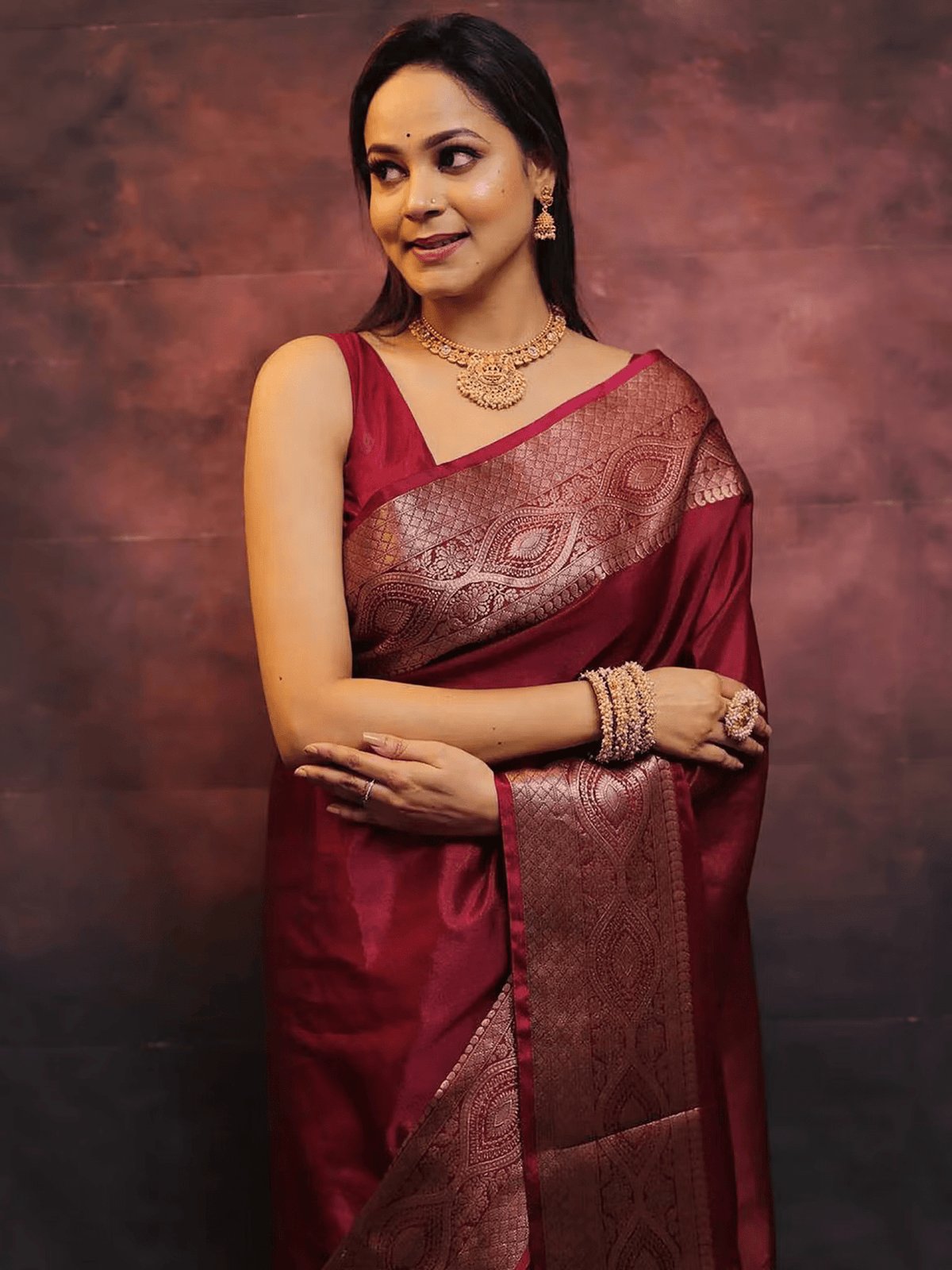 Aromie elegant festive saree set in deep maroon with intricate zari work worn by woman with gold jewelry