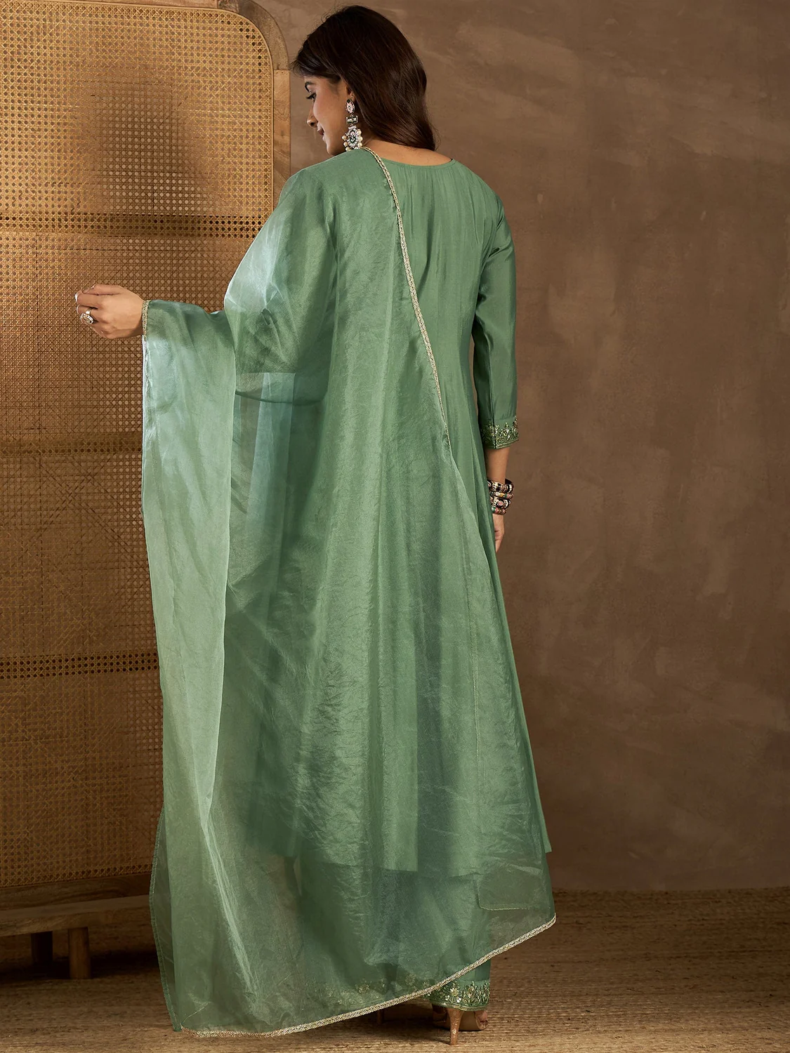 Back view of a green embroidered Anarkali Kurta Canada set made of lightweight fabric, perfect for festive occasions.