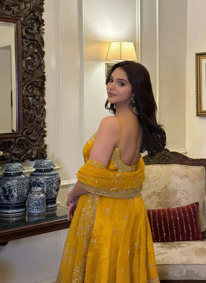 Model wearing an embroidered vichitra silk kurta set in vibrant yellow, showcasing intricate designs