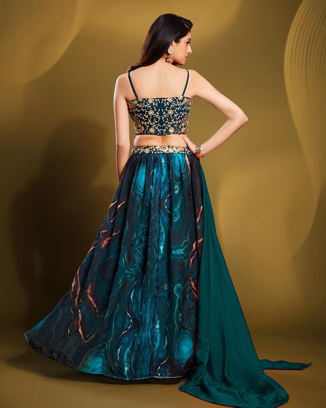 Back view of model in teal embellished lehenga choli set Canada with embroidered strappy choli and flowing skirt