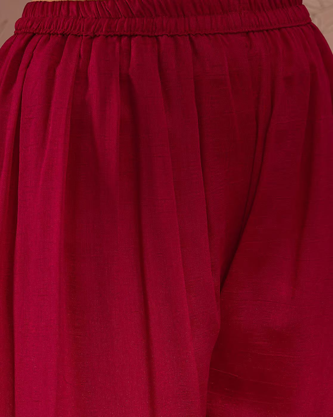 Close up of red pleated palazzo pants with elastic waist from aromie elegant white kurta set three piece
