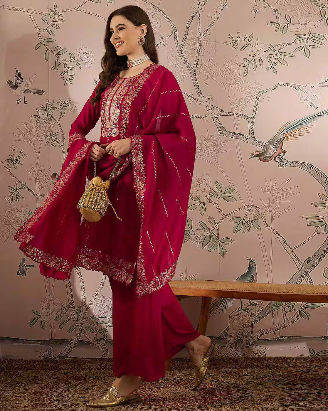 Aromie red three piece kurta set with intricate gold embroidery, model holding potli bag, elegant white kurta set