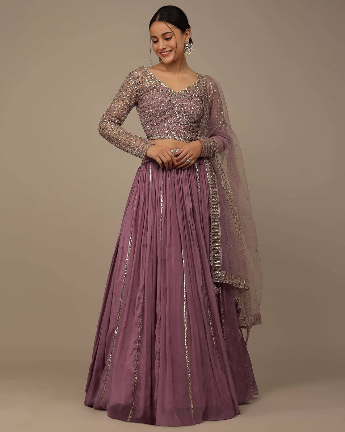 Model wearing mauve embroidered blouse and flowing skirt with sheer dupatta in embellished lehenga choli set Canada