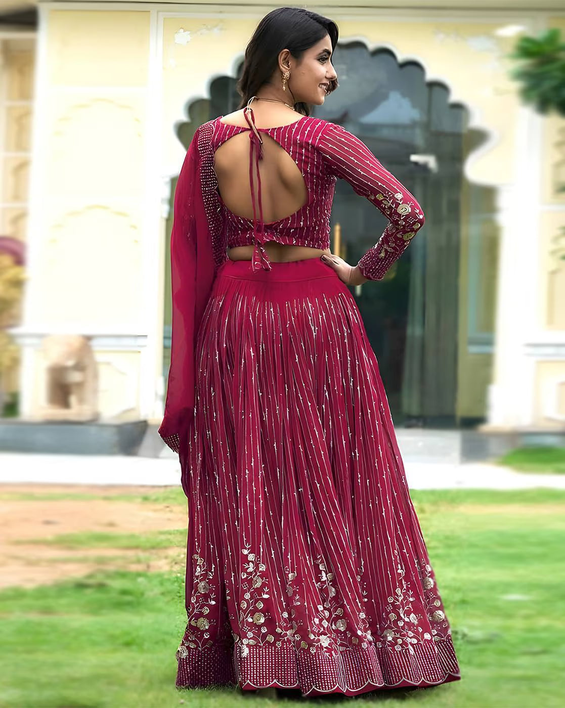Back view of model in magenta embroidered lehenga choli set Canada open back tie long sleeve choli with floral embroidered hem