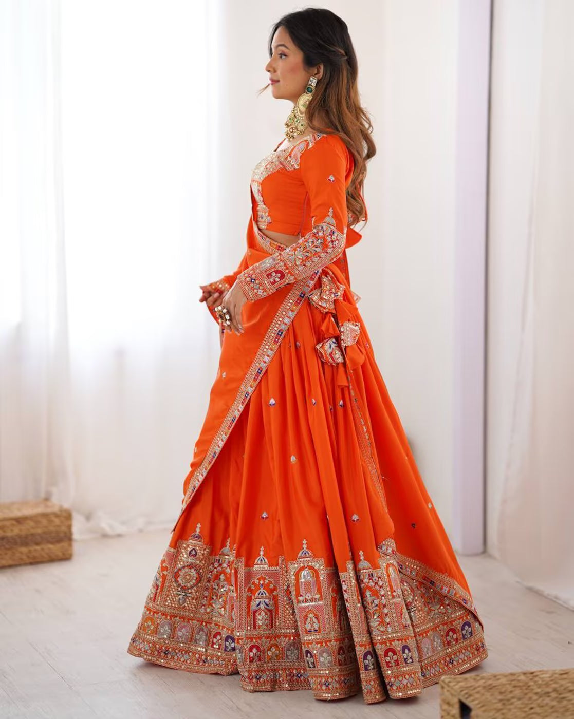 Model wearing orange embroidered lehenga choli set Canada with gold border embroidery flared skirt and matching dupatta