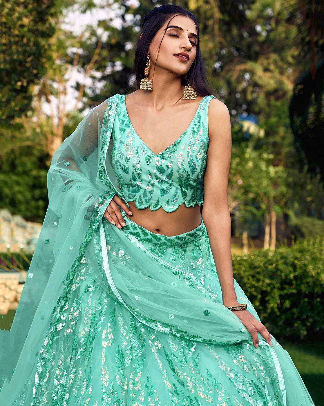 Mint green women embellished lehenga choli set with sequined blouse, embroidered flowing skirt and sheer dupatta for weddings