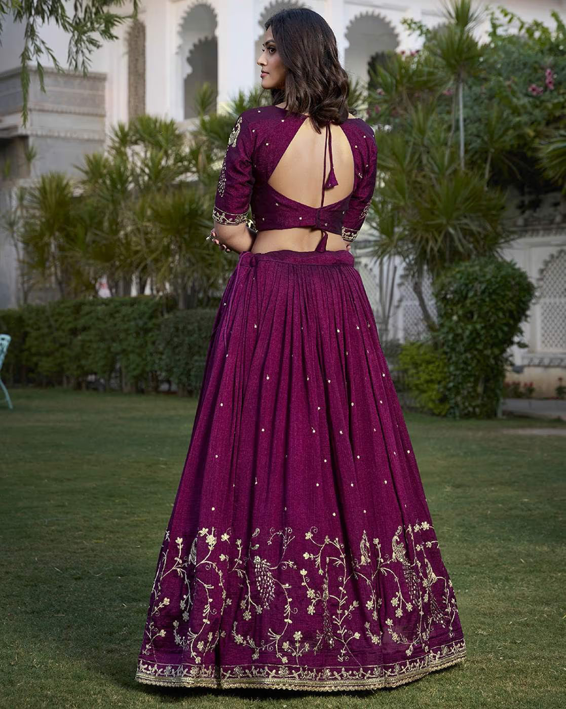 Back view of woman in AROMIE women's embroidered lehenga choli set deep plum open back blouse with gold floral embroidery