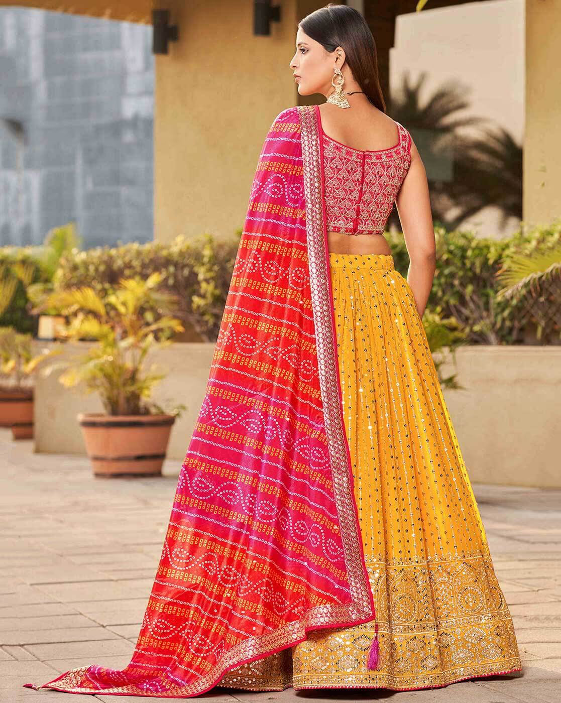 Back view embroidered lehenga choli set Canada with pink blouse yellow mirrorwork skirt and red bandhani dupatta