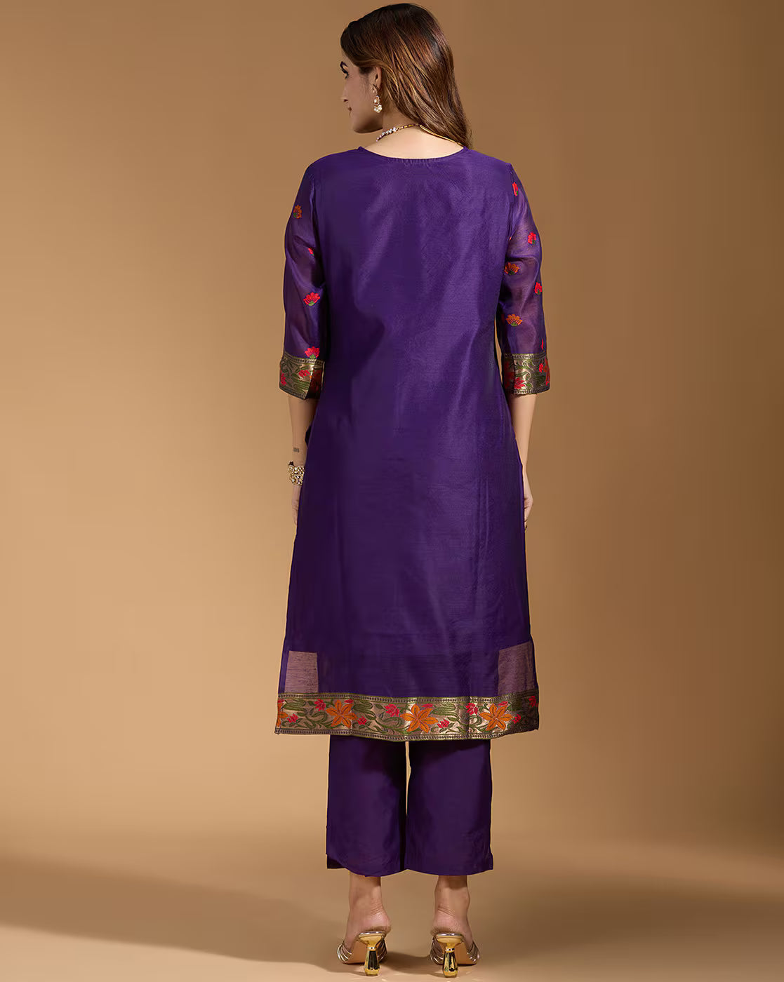 Aromie three piece teal floral kurta set back view on model wearing purple kurta with floral border and straight pants