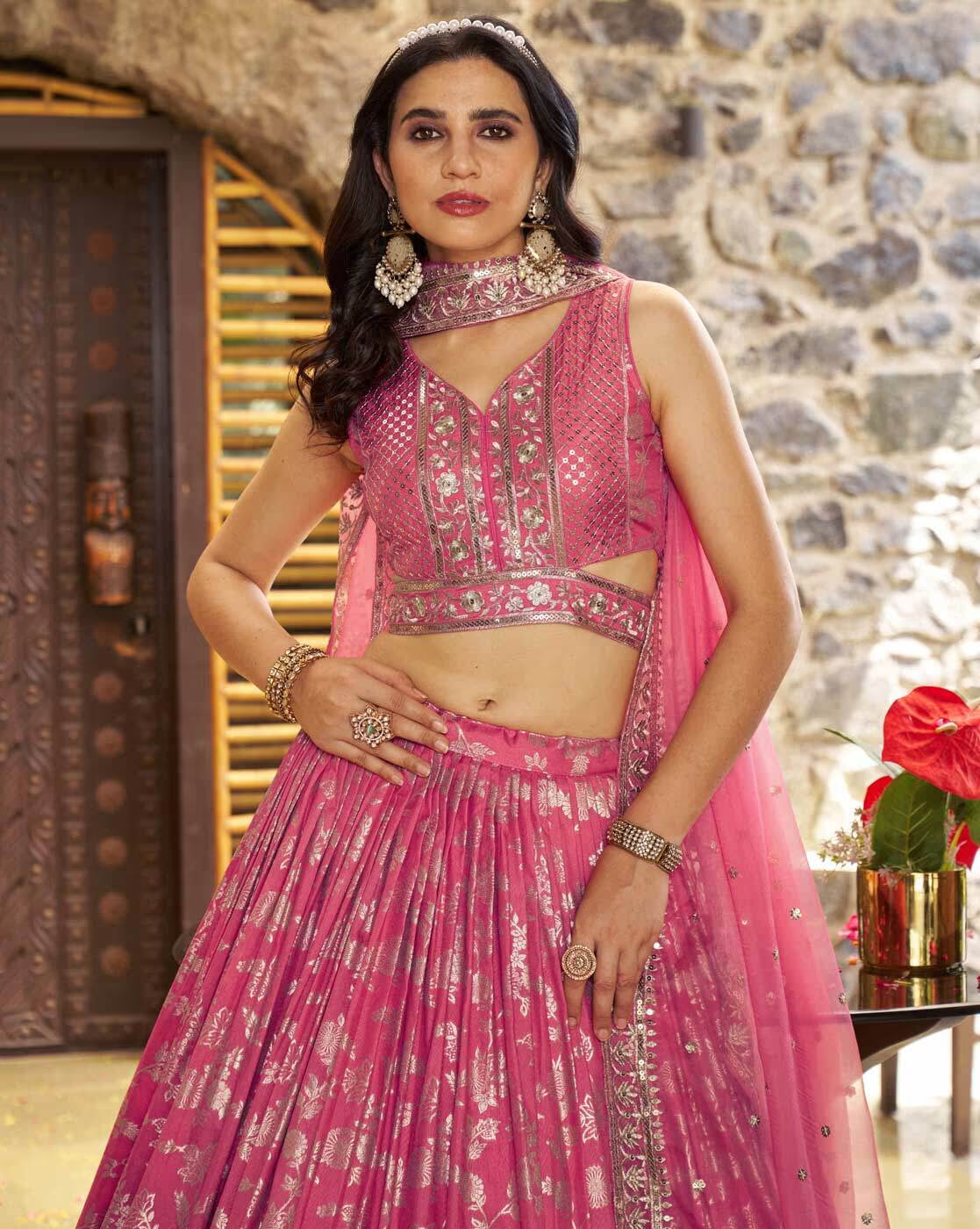 Model wearing pink embroidered lehenga choli set Canada with sleeveless mirrorwork blouse flared skirt and dupatta