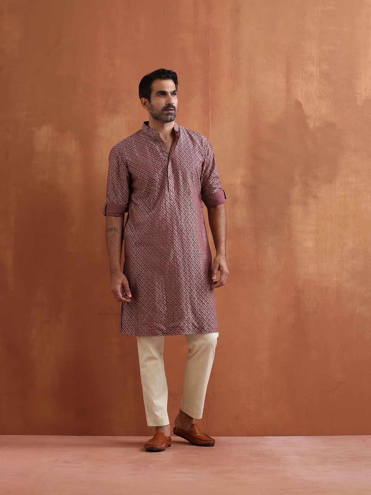 Male model in men's purple cotton kurta with geometric print, rolled sleeves, beige pants and brown loafers