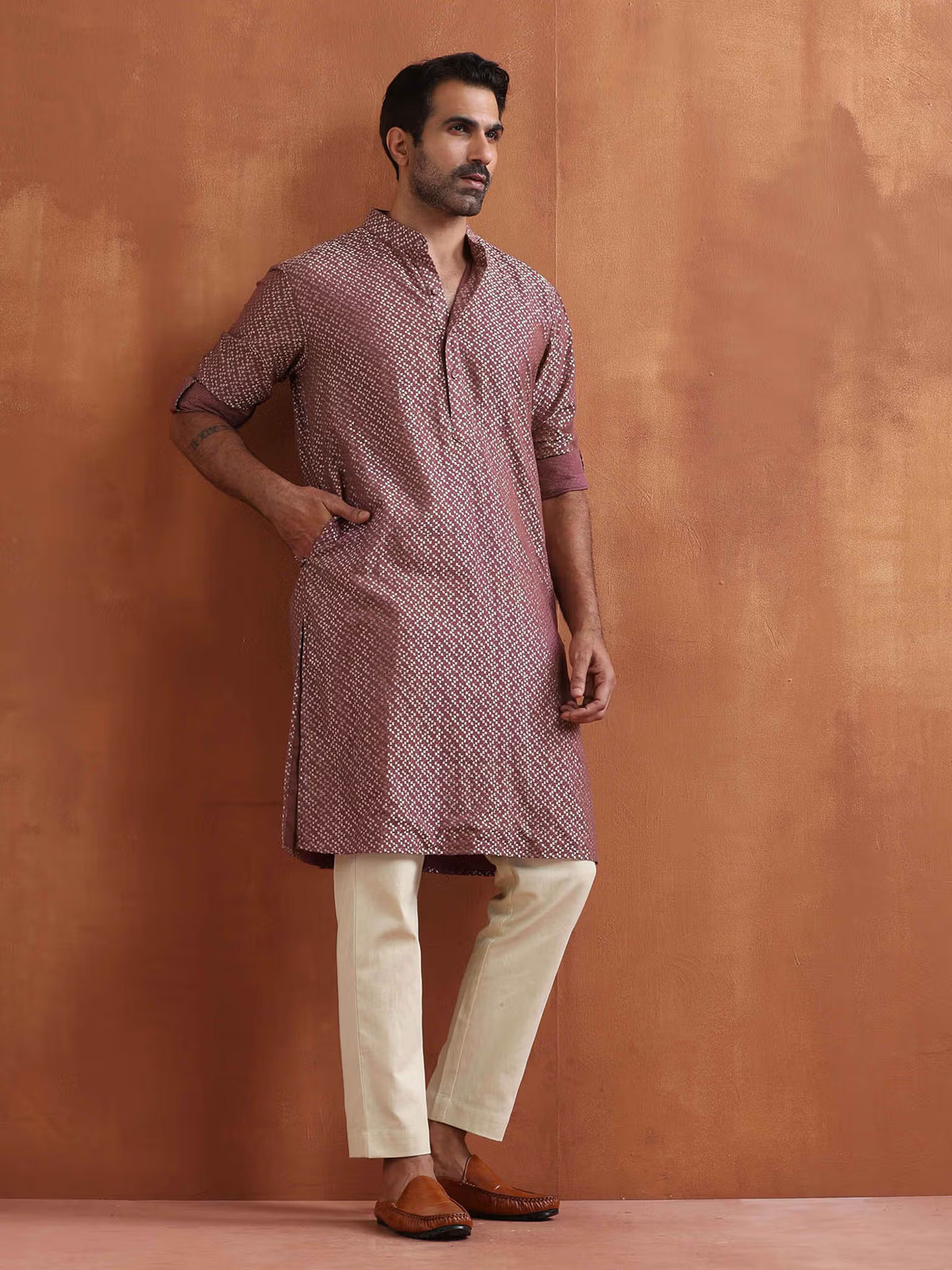 Male model wearing men's purple cotton kurta with geometric print, cream trousers and brown loafers, hands in pocket