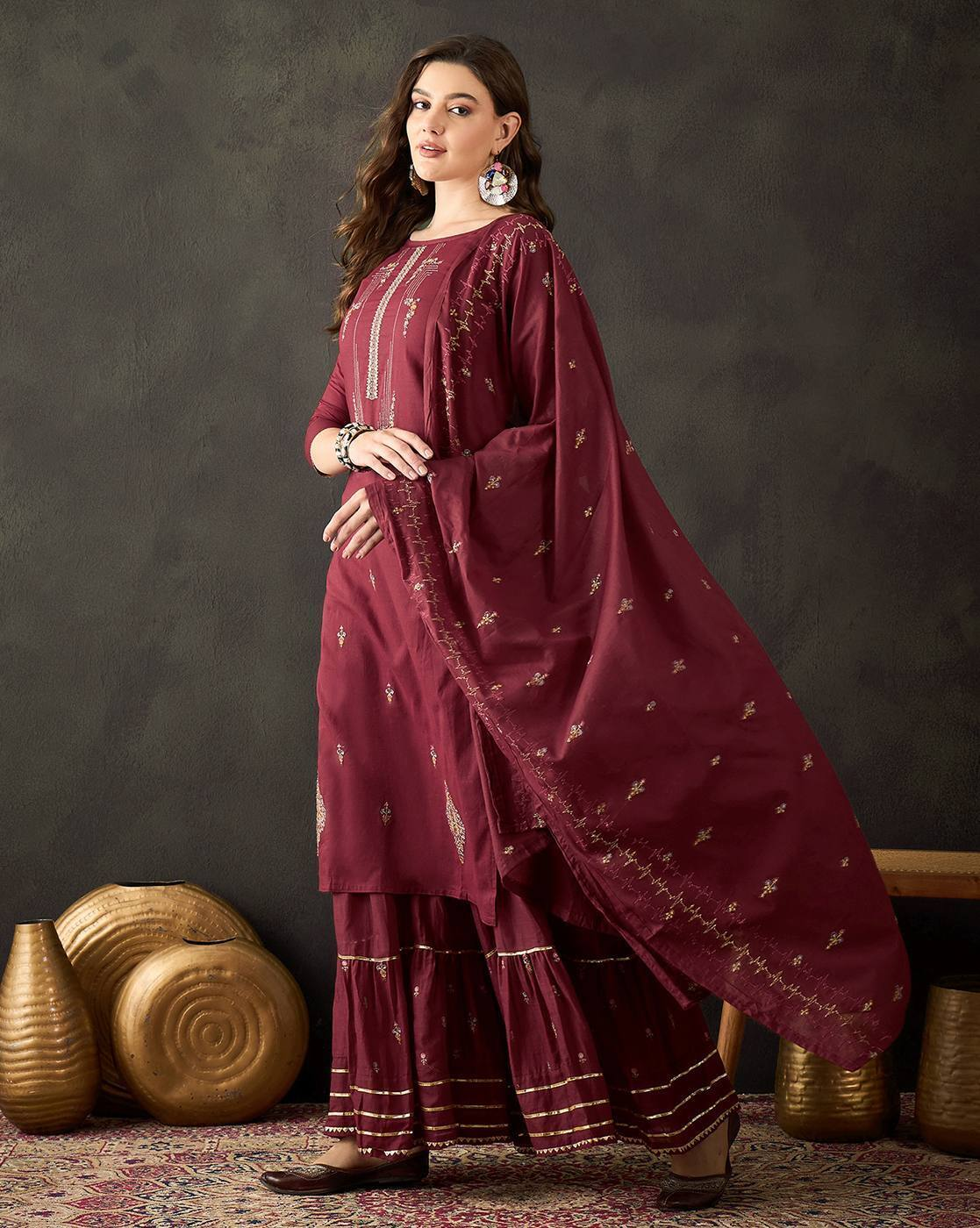 Aromie three piece floral embroidered cotton kurta set in maroon worn by a woman with matching dupatta and palazzo pants