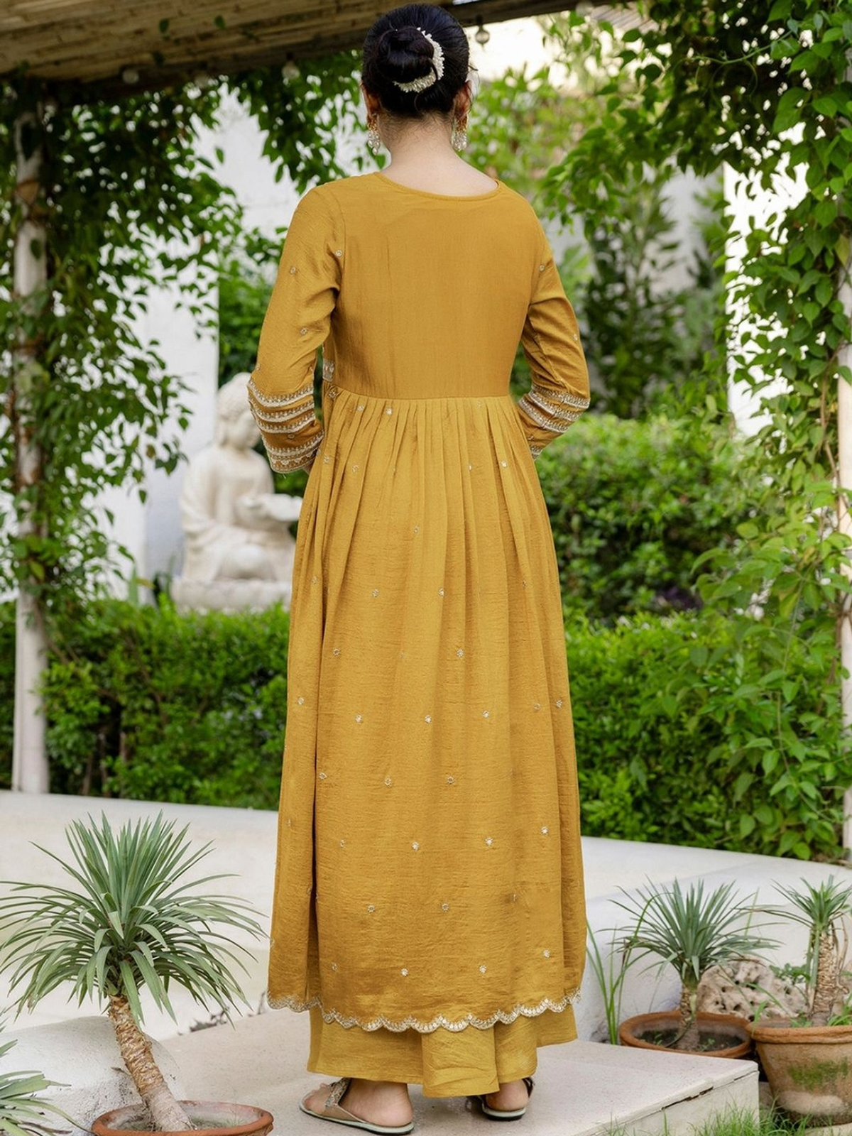 Back view of a floral embroidered kurta sharara set in mustard with intricate detailing and flowy design