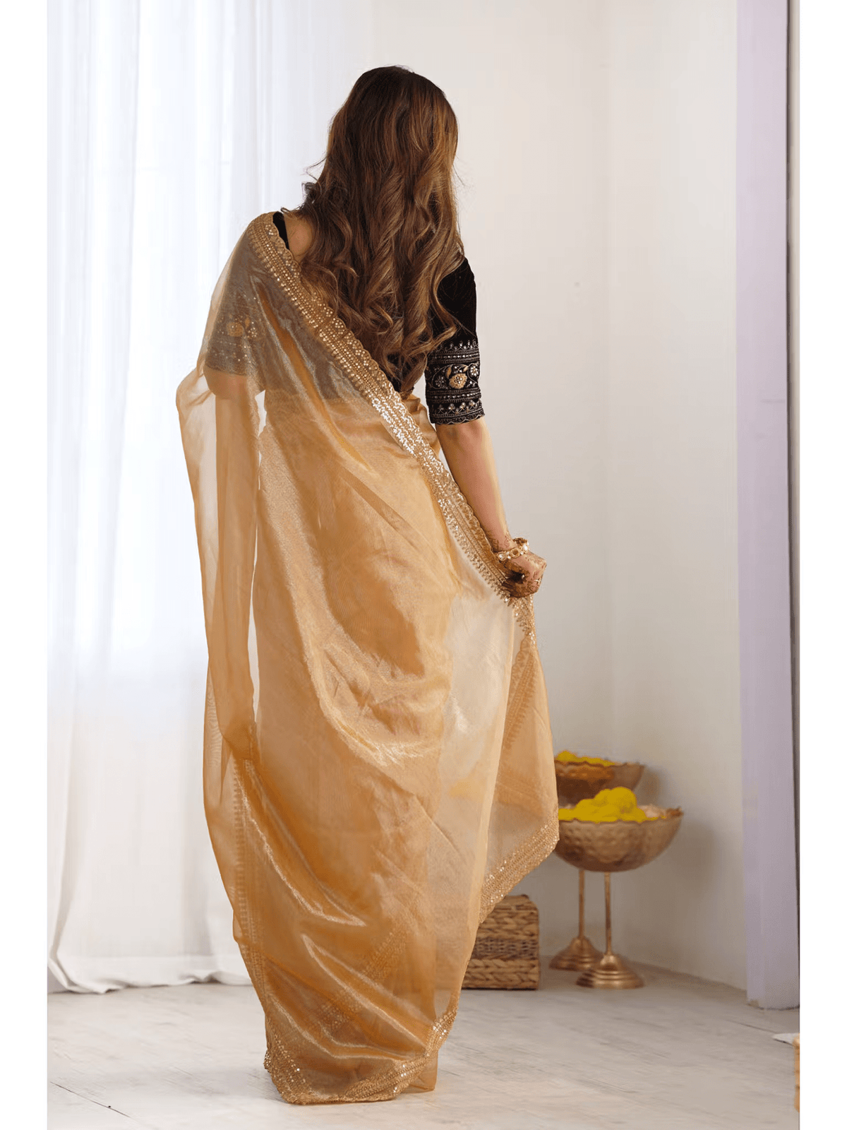 Aromie gold silk party wear saree Canada styled on model with black blouse in bright indoor setting