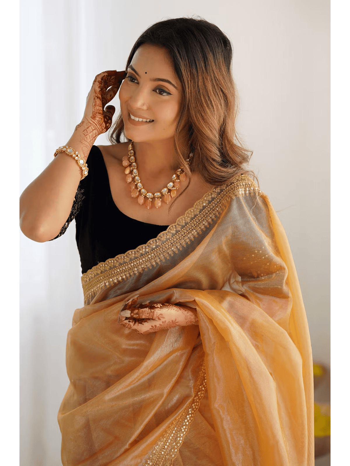 Woman wearing Aromie Gold Silk Party Wear Saree Canada with intricate gold border and black blouse