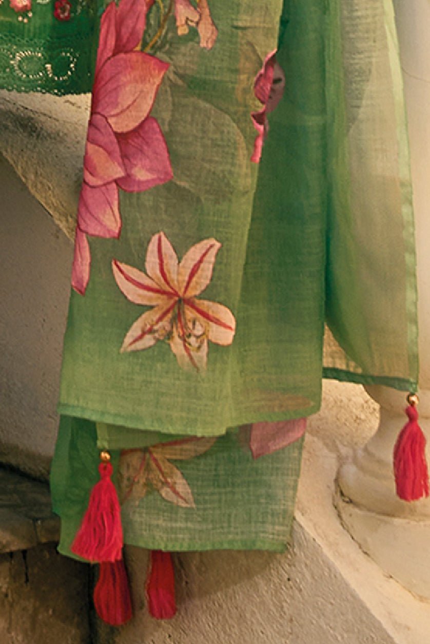Green embroidered kurta set with vibrant floral designs and tassel details on the dupatta
