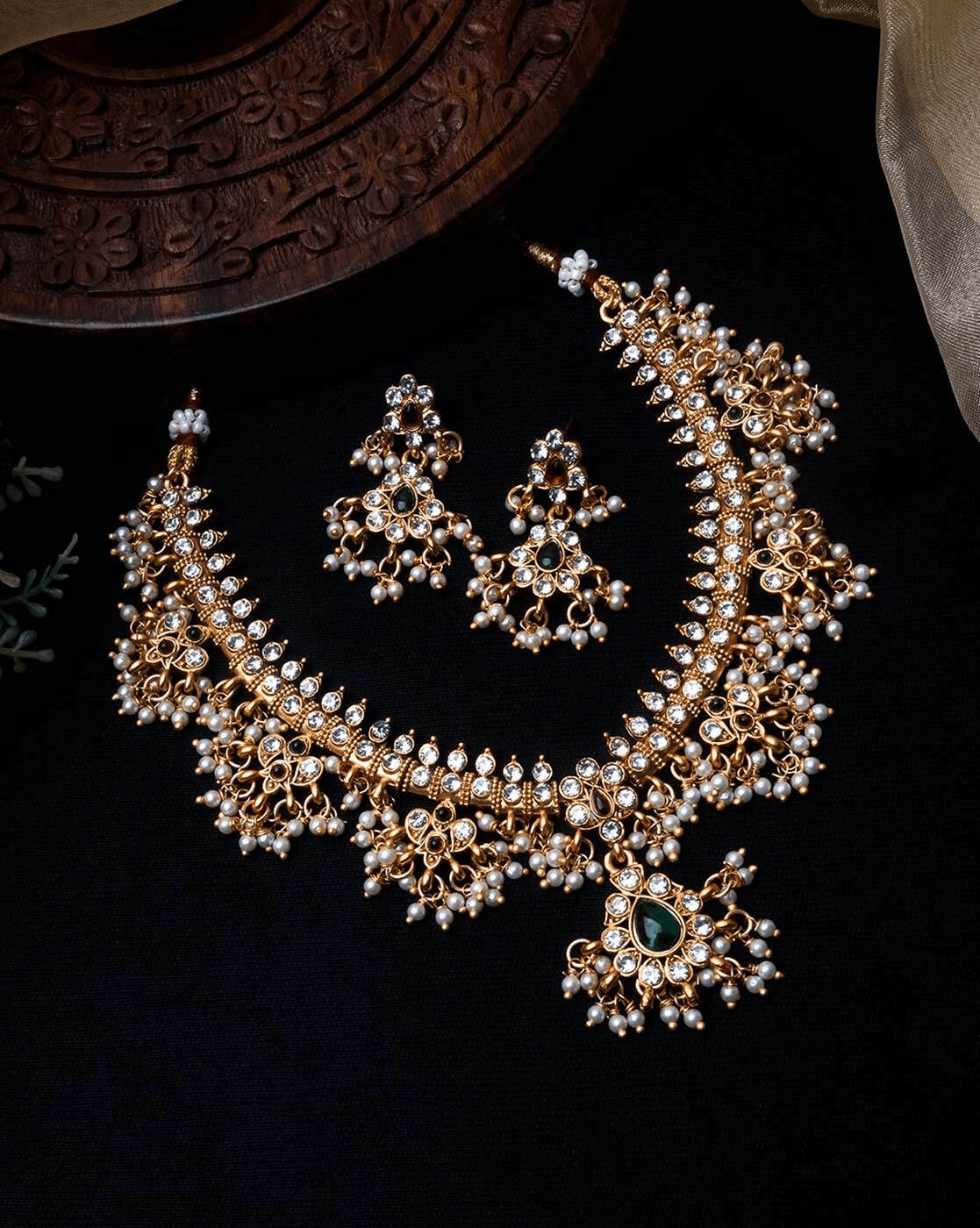 Aromie vintage gold-plated necklace set with intricate Kundan style, pearl drops and green stone pendant