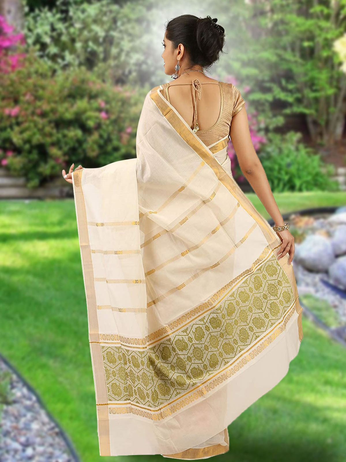 Aromie Ikat saree with zari border in cream and gold worn by a woman standing outdoors