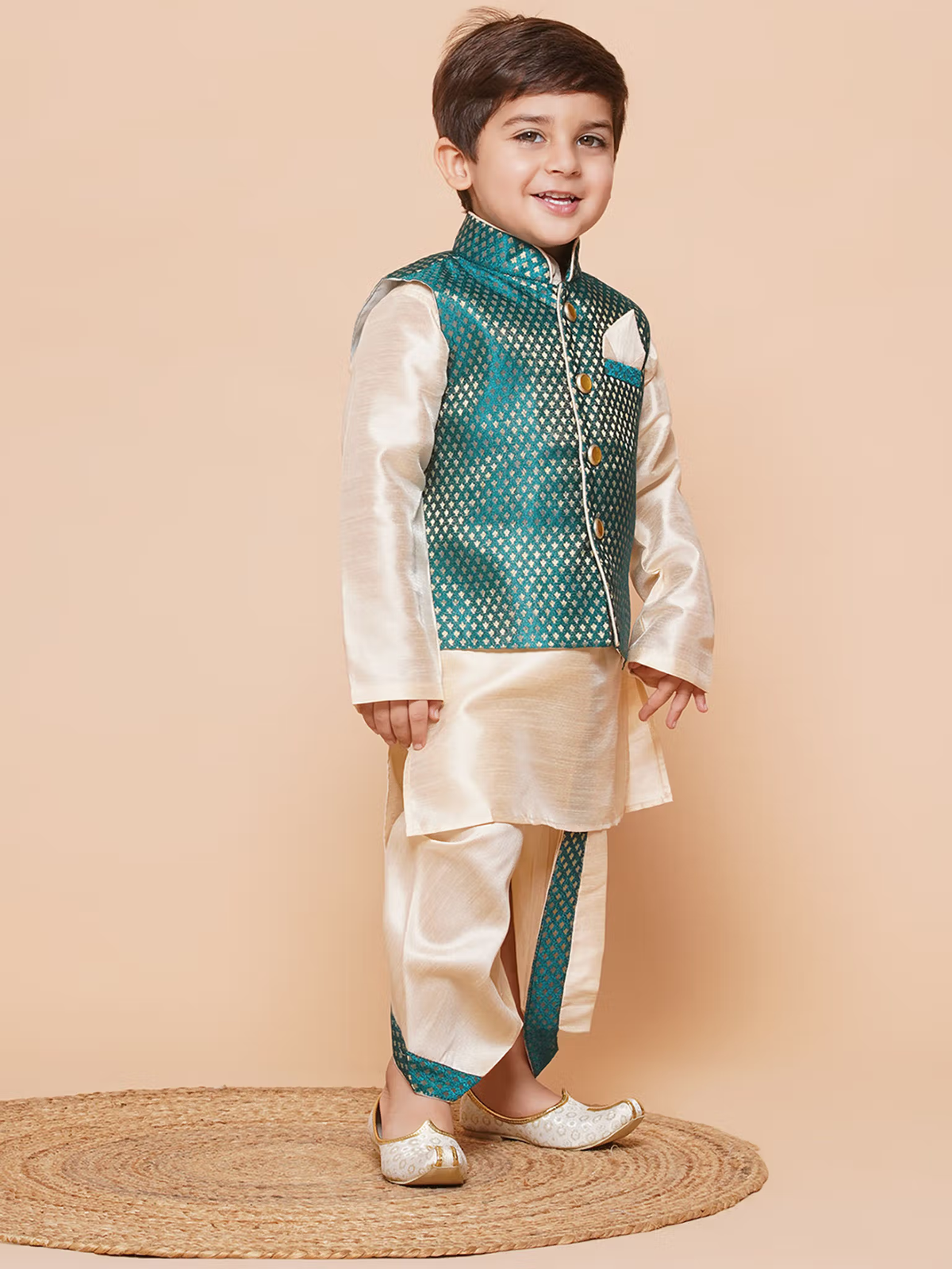 Young boy modeling boys green silk dhoti kurta set with teal brocade jacket and cream silk kurta