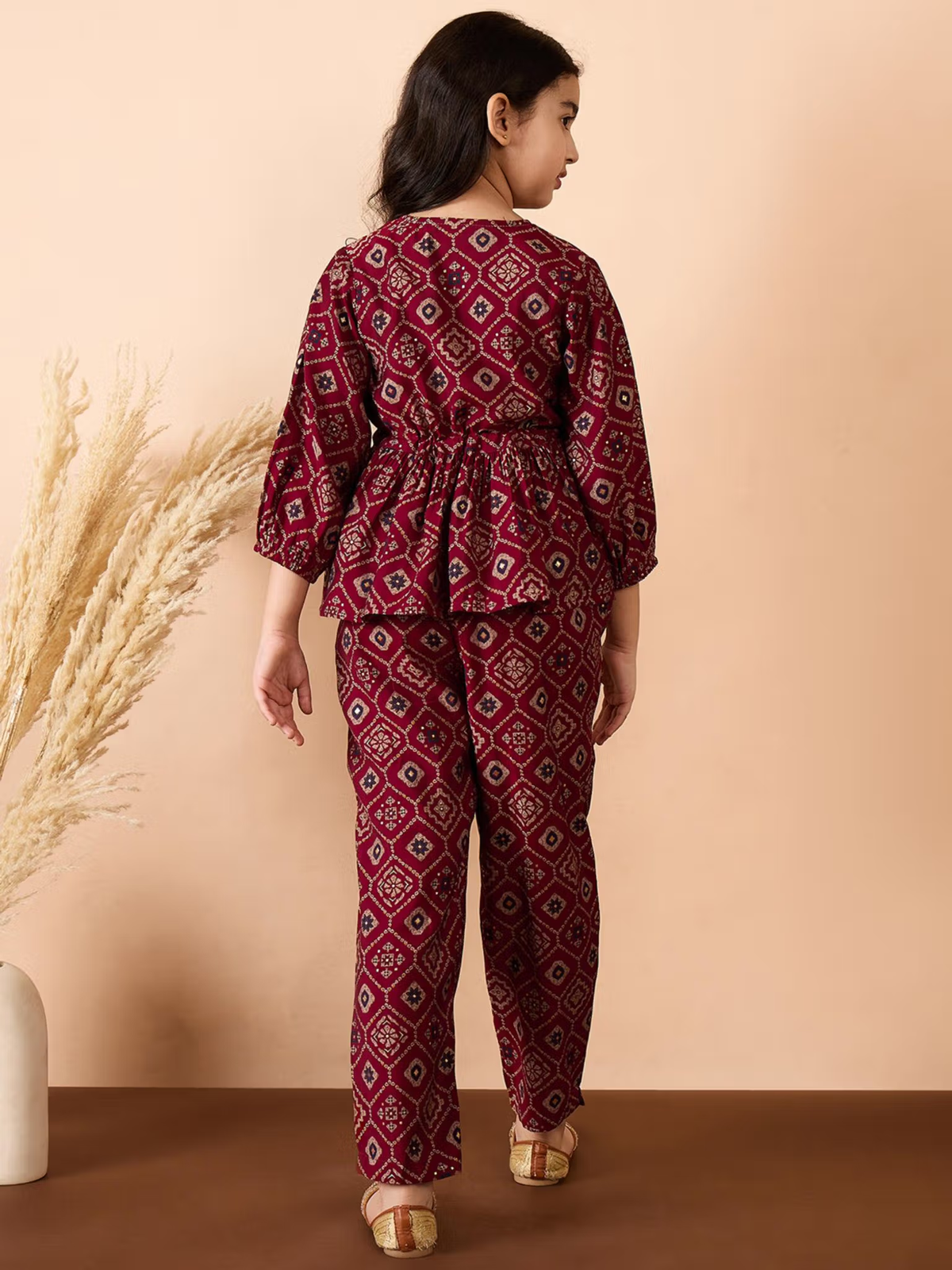 Back view of girl in maroon printed Girls Georgette Kurta Set with gathered waist peplum and matching pants