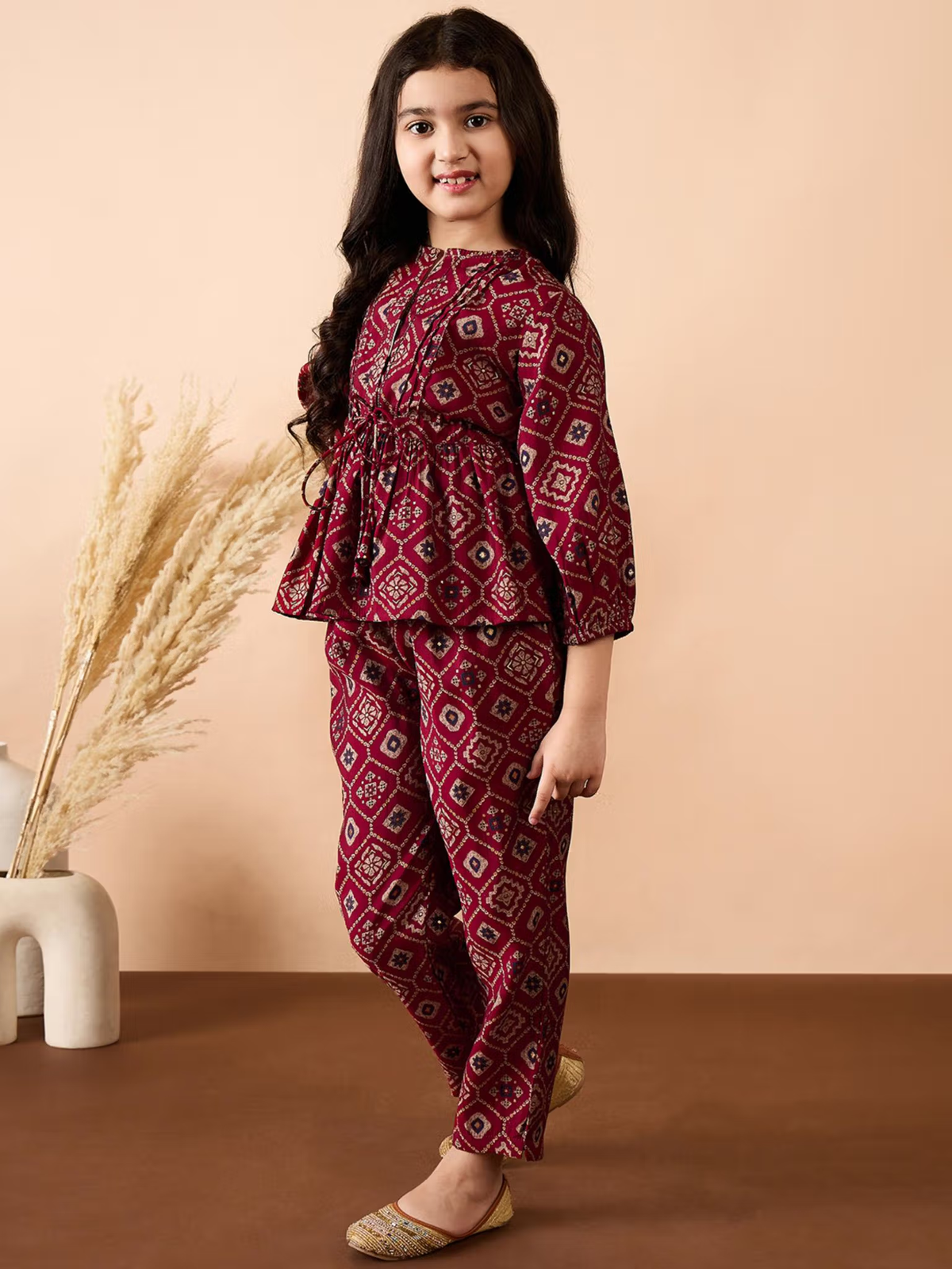 Aromie Girls model wearing maroon geometric printed Girls Georgette Kurta Set with peplum top and straight pants