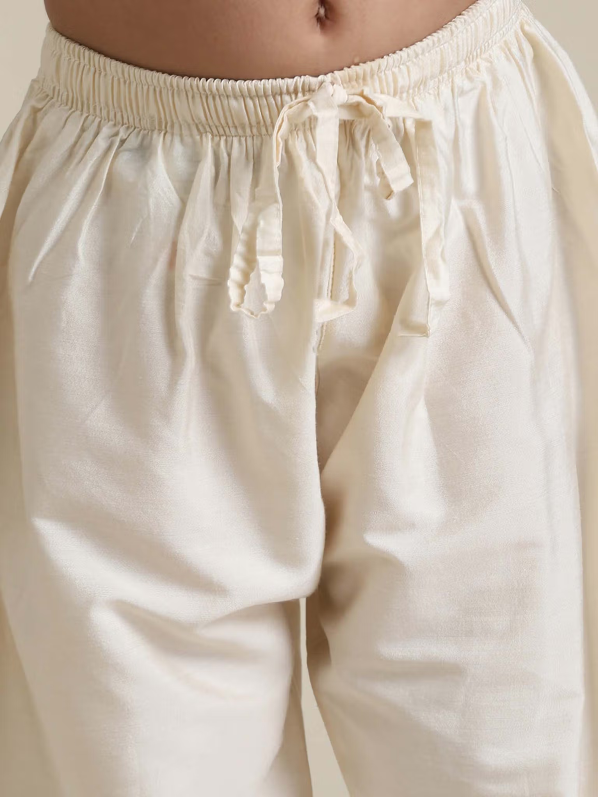 Cream pyjama pants with elastic waistband and drawstring from kids rust floral kurta pyjama set by AROMIE