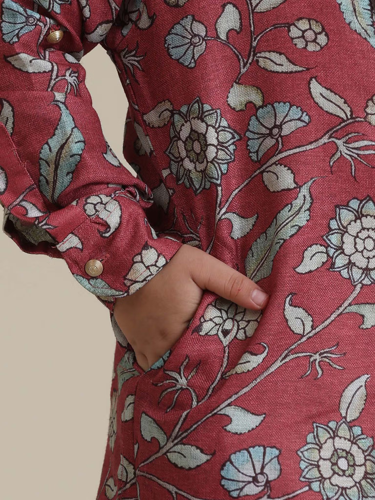 kids rust floral kurta pyjama set closeup showing rust floral print boys kurta with hand in pocket and button cuff