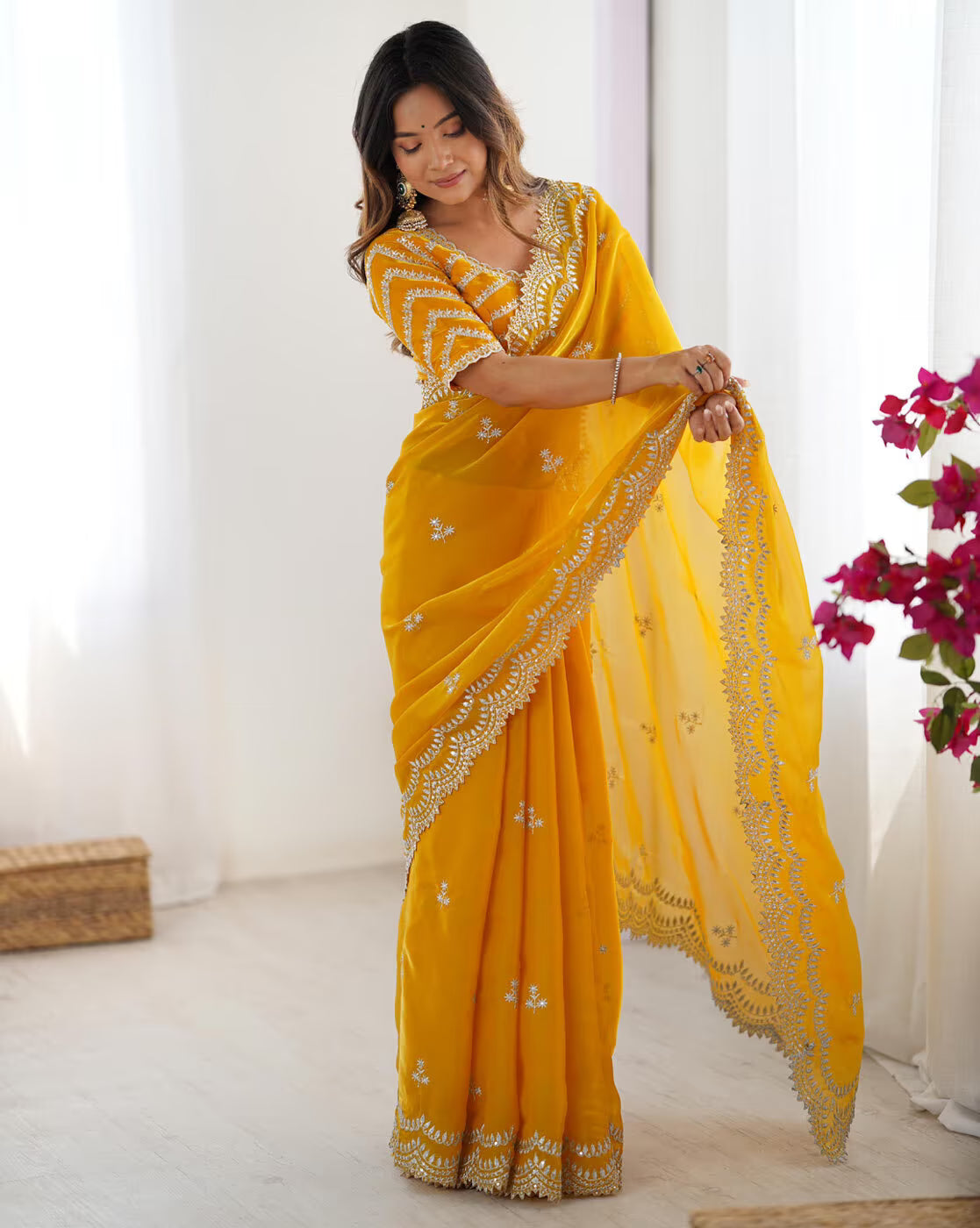 Elegant woman wearing a Madhu Bani silk saree online in vibrant yellow with intricate embroidery