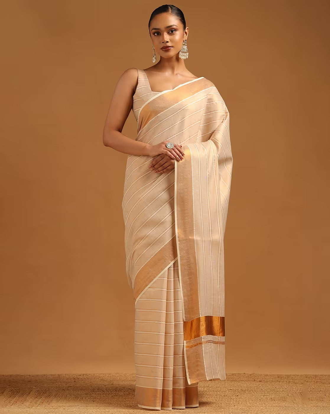 Elegant beige saree in silk blend with gold stripes for festive occasions and celebrations