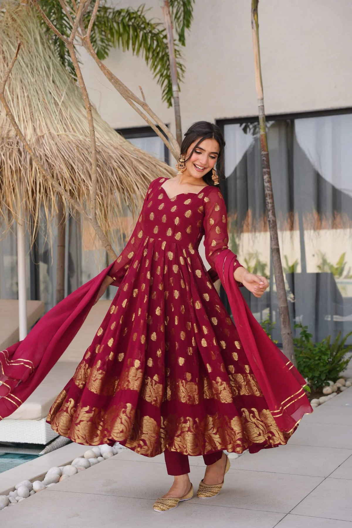 Maroon anarkali suit set with gold detailing, ideal for weddings, featuring a front view and flowy silhouette.