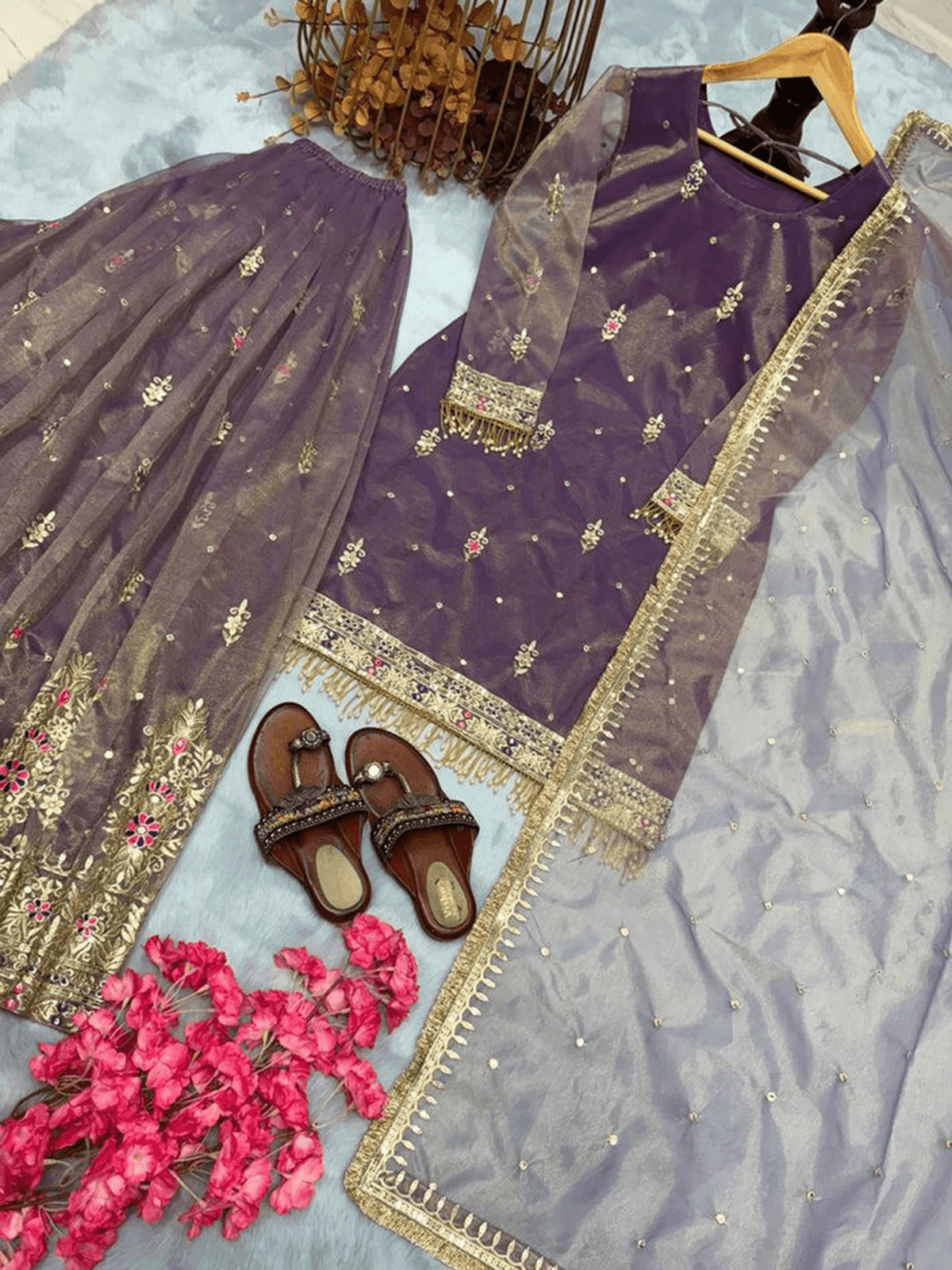 Maroon embroidered kurta set featuring intricate designs with matching accessories and floral decor