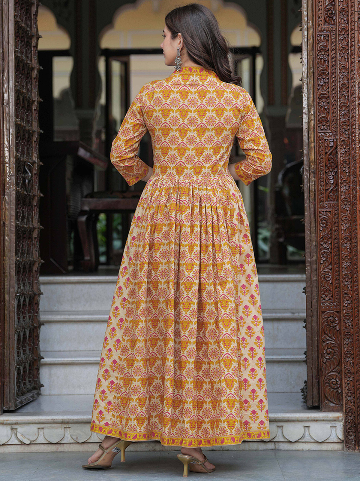 Back view of mustard yellow anarkali kurta set in patterned fabric, ideal for festive occasions