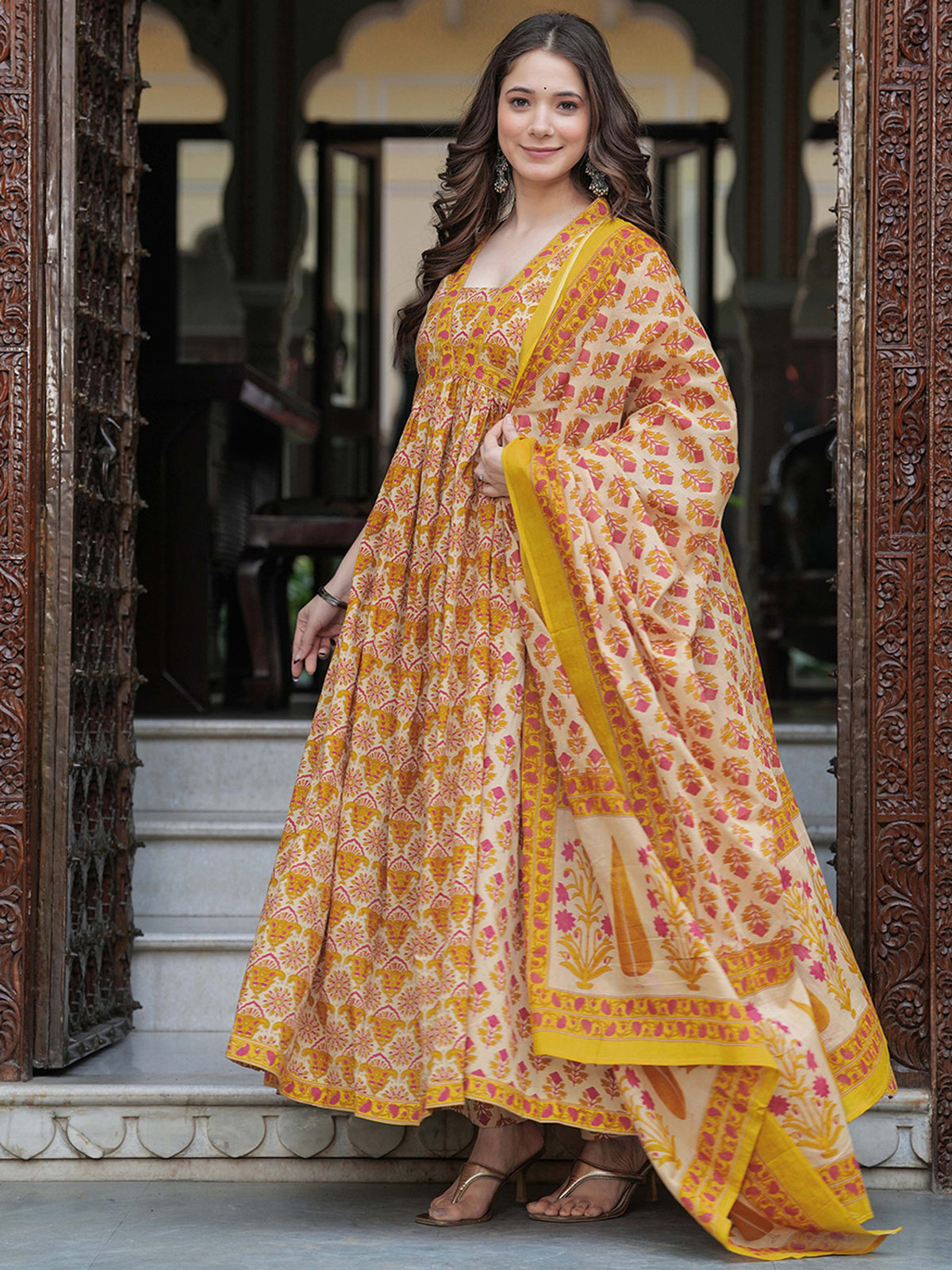 Mustard yellow anarkali kurta set with intricate floral patterns, ideal for festive events and weddings
