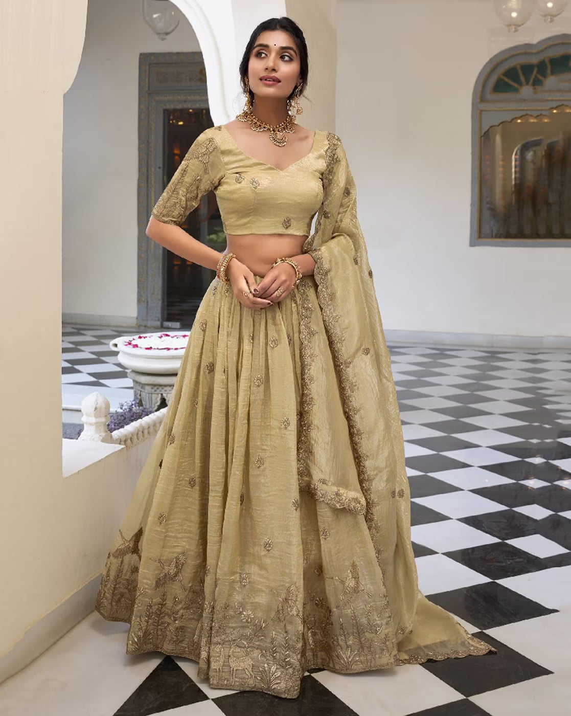 Model wearing embroidered lehenga choli set Canada in muted gold with intricate embroidery matching dupatta and jewelry