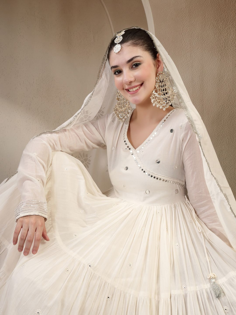 Model wearing an off white Anarkali kurta set Canada with intricate embroidery and flowing fabric