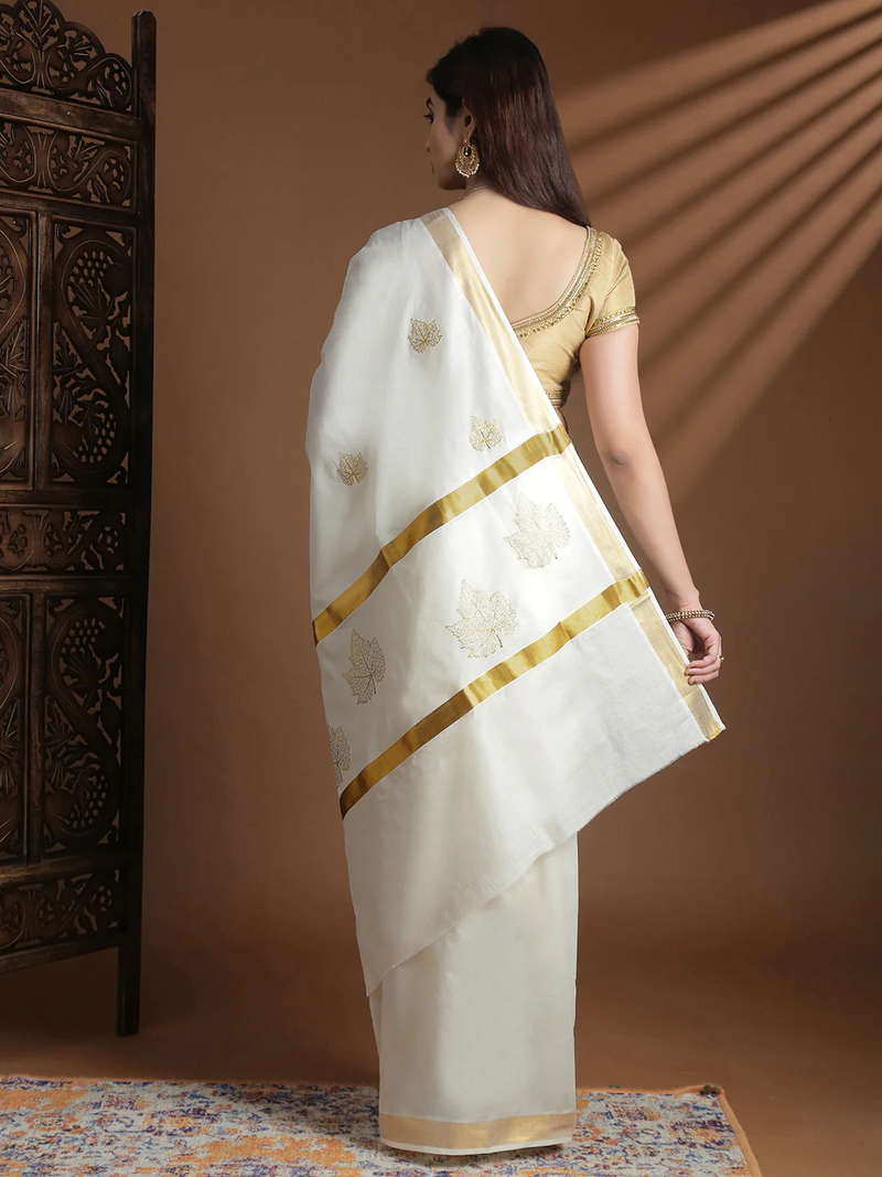 Elegant white Onam saree from Aromie with golden floral embroidery, perfect for festive celebrations