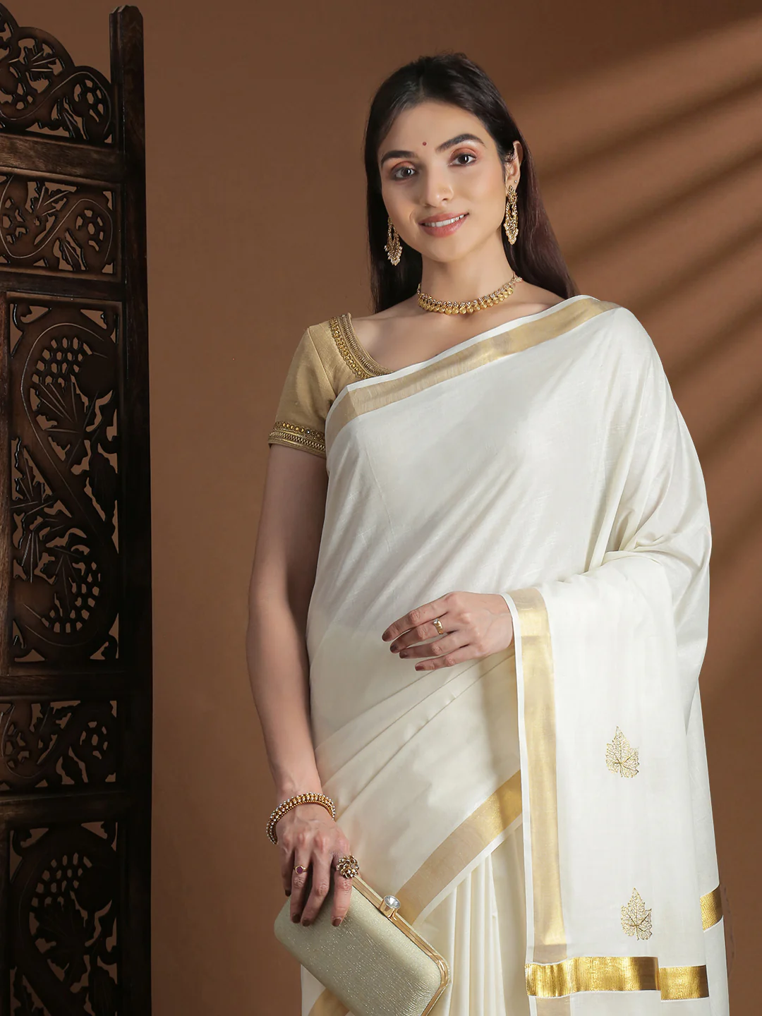 Elegant white Onam saree with golden border in soft fabric, perfect for festive celebrations and weddings