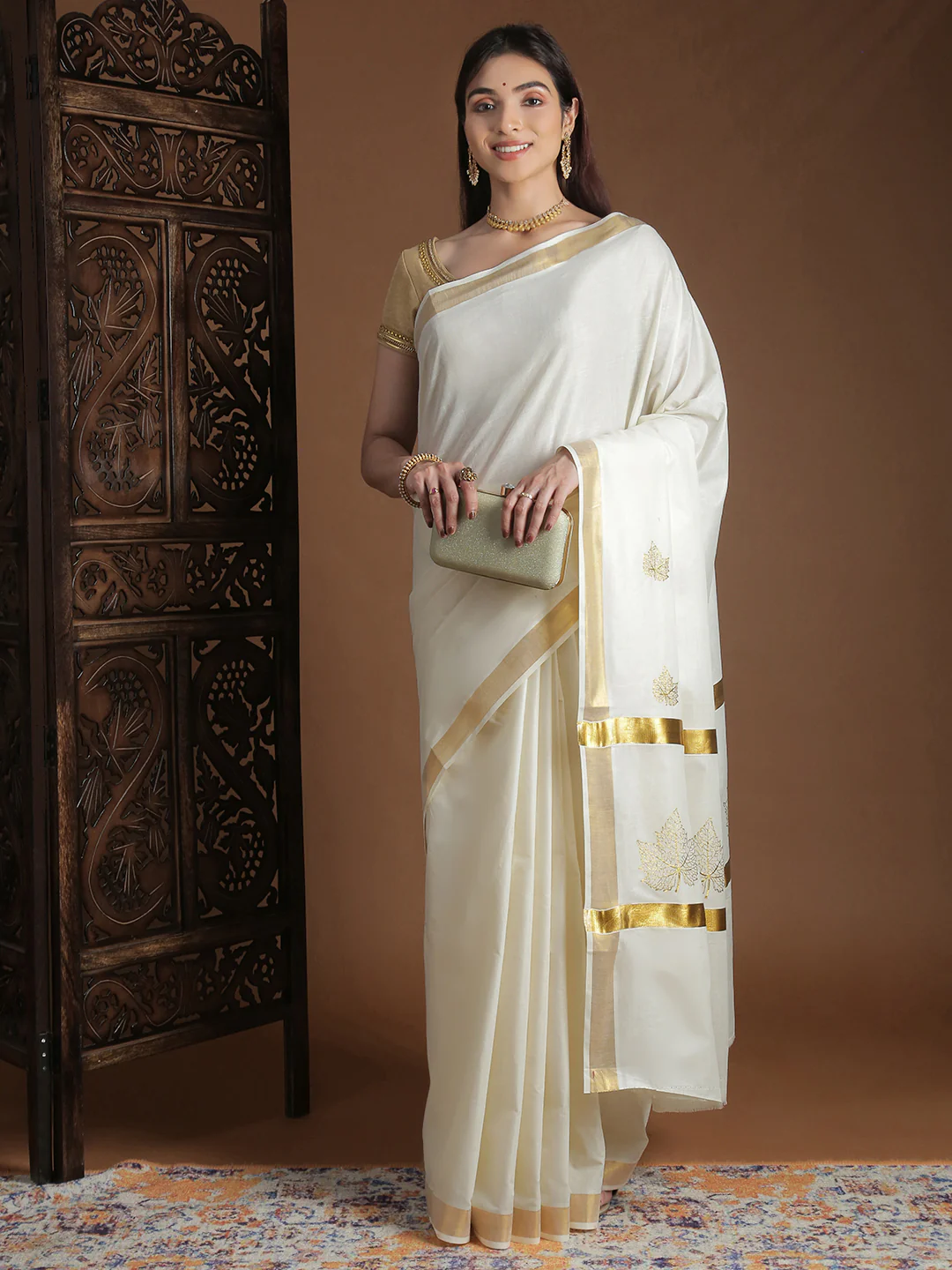 Elegant cream onam saree with golden border and floral embroidery, ideal for festive celebrations