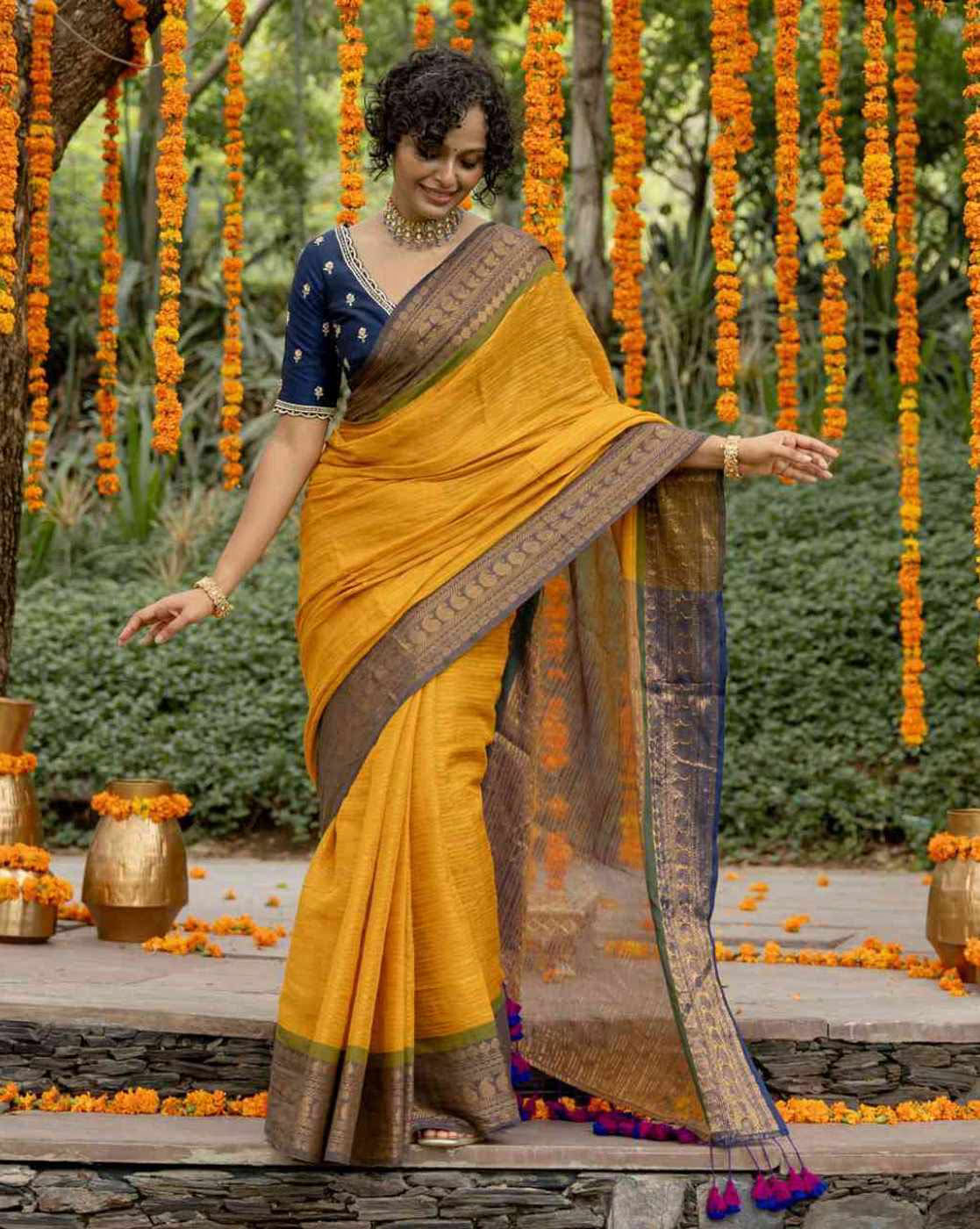 Stylish yellow organza saree with stone work, paired with a blue embroidered blouse for festive occasions