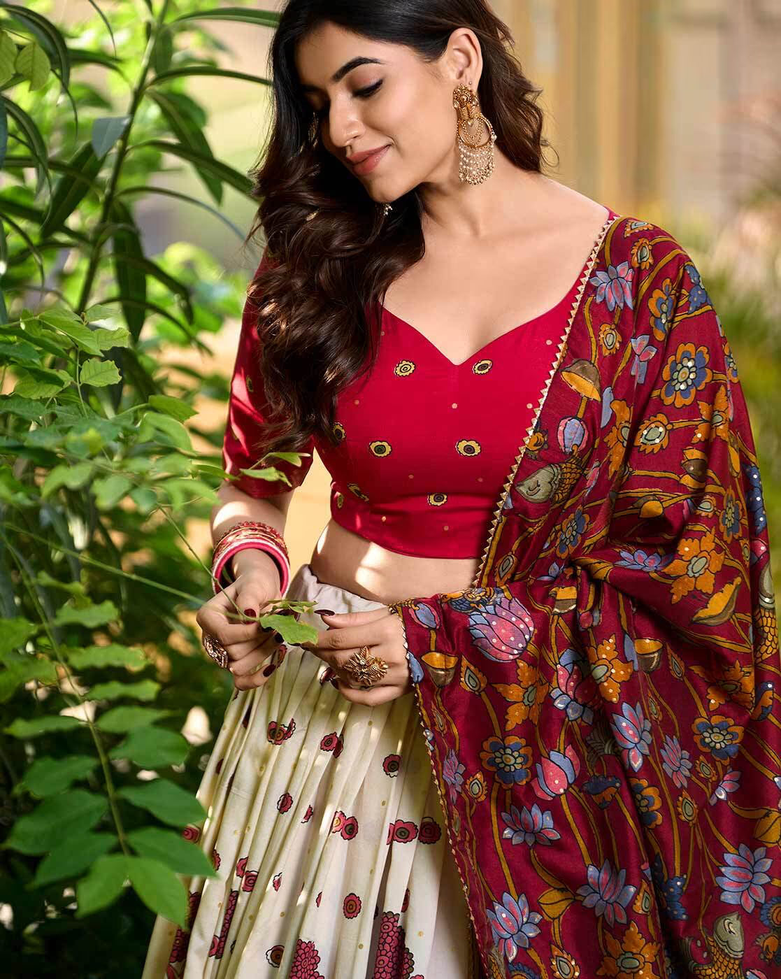 Model wearing red blouse cream embroidered skirt and floral maroon dupatta lehenga choli set Canada by AROMIE