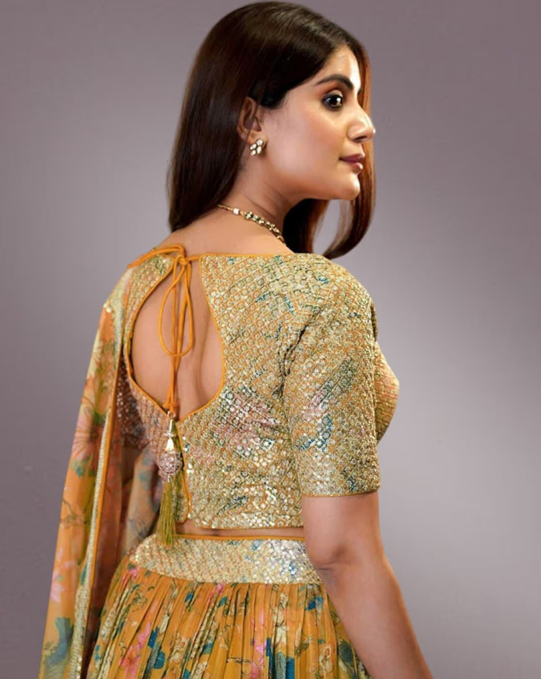 Woman wearing a gold embroidered blouse and floral skirt with dupatta women embroidered lehenga choli set