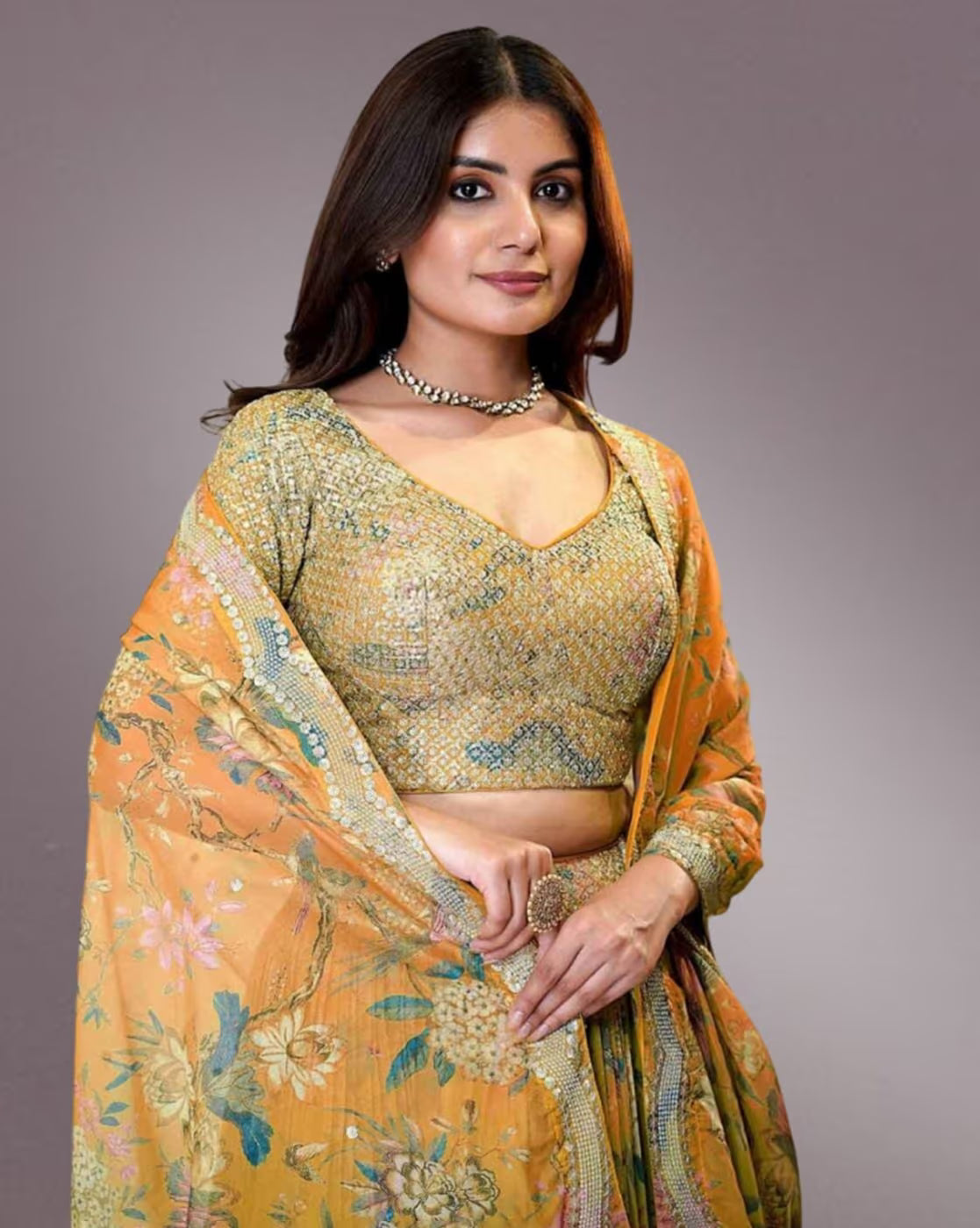 Model wearing mustard floral women embroidered lehenga choli set with matching dupatta and necklace