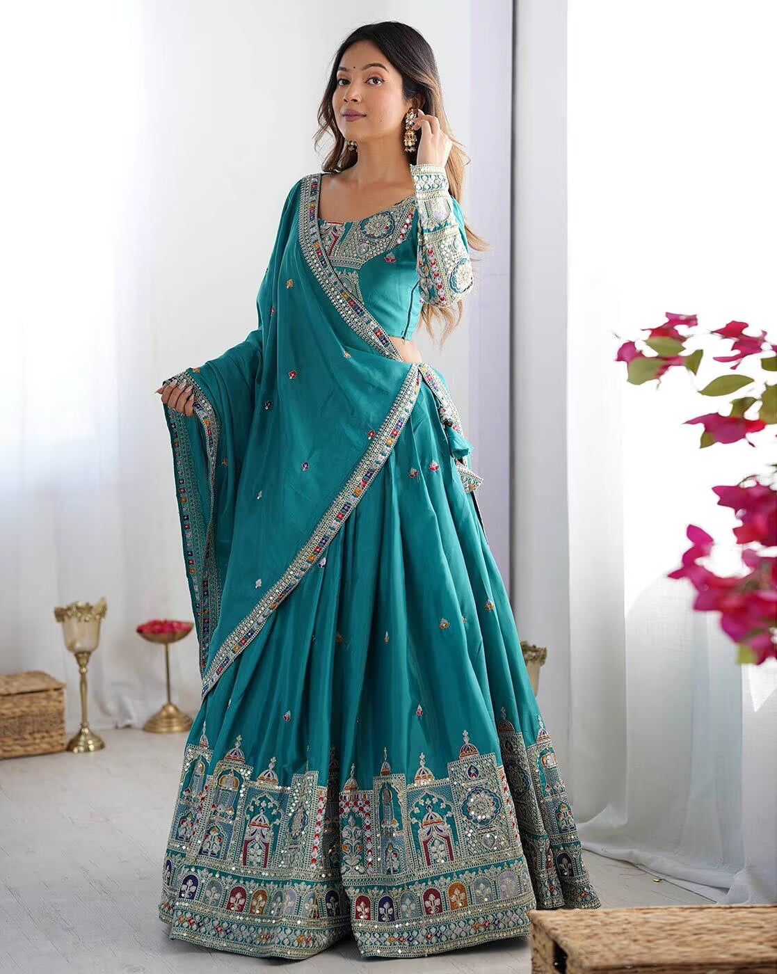 Model wearing teal embroidered lehenga choli set Canada with ornate border embroidery long sleeve choli and draped dupatta